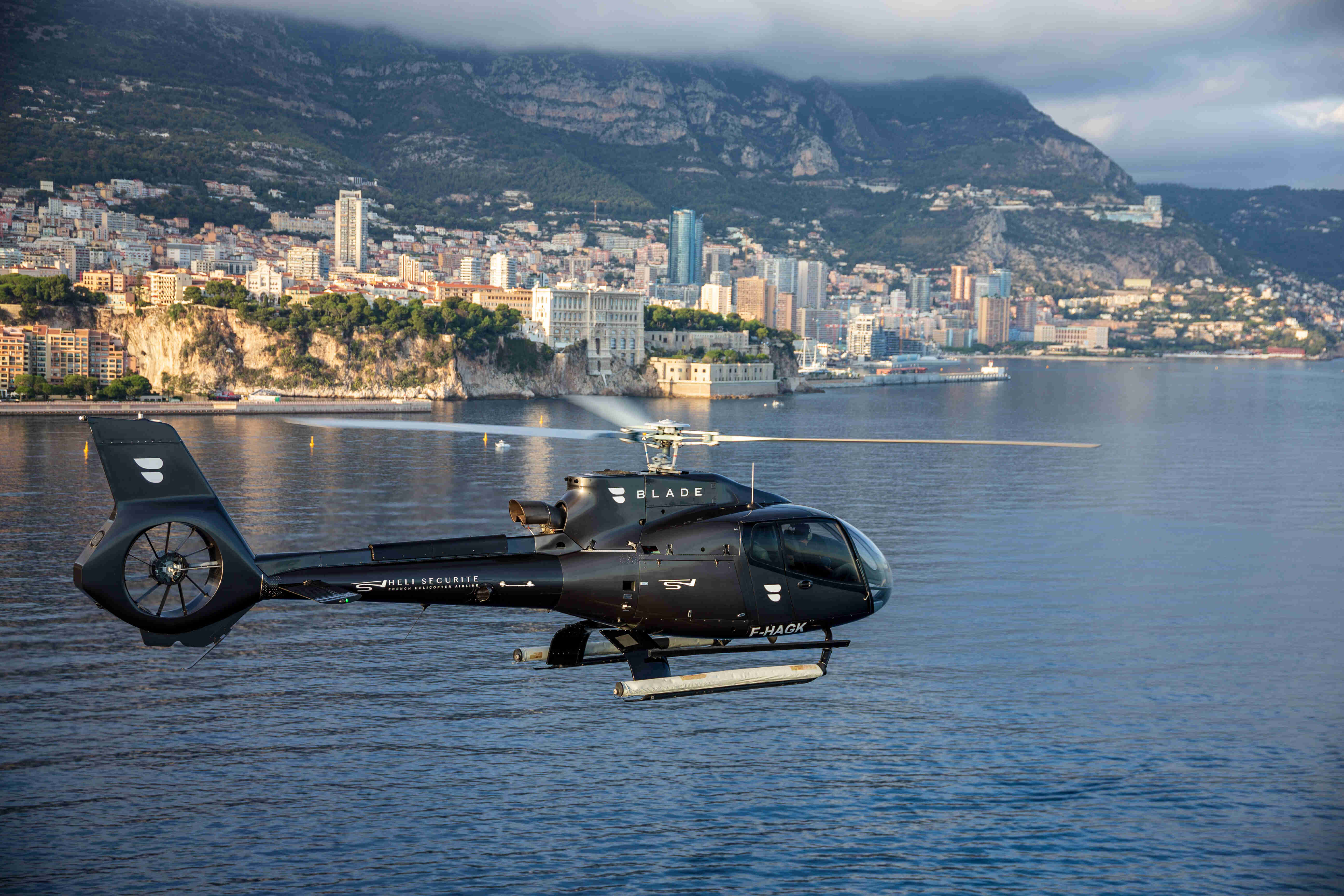 Hélicoptère privé au-dessus de la Riviera, Monaco en arrière-plan