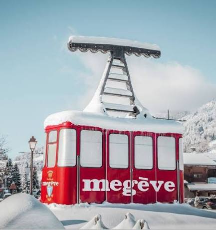 Célèbre cabine rouge de Megève sous la neige, face aux cimes